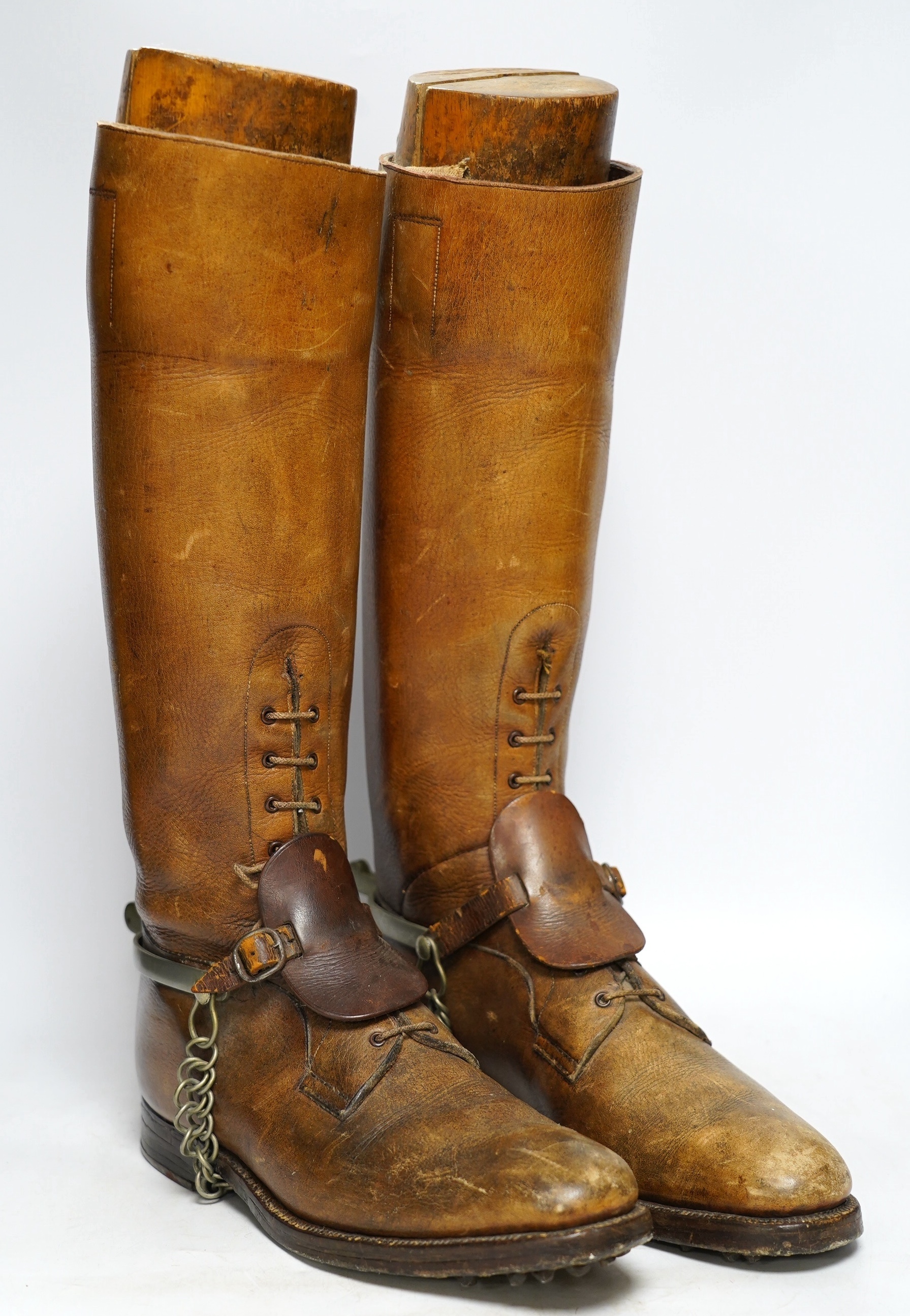 A pair of military First World War boots in tan leather, hobnail soles, two-part wooden shoe trees, and spurs. Condition - fair to good, some rubbing, fading and staining to the leather